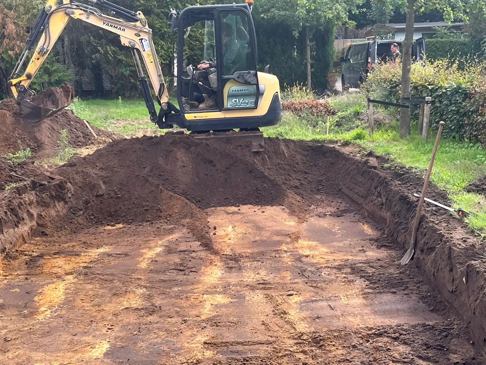 Yanmar SV26 minigraver met een bak vol grond tijdens het uitgraven van een kavel op een park in Putten